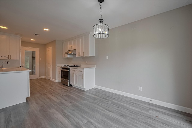11502 Leader St, Houston, TX 77072 - kitchen with gas stove, white cabinetry, under cabinet range hood, recessed lighting, and light countertops