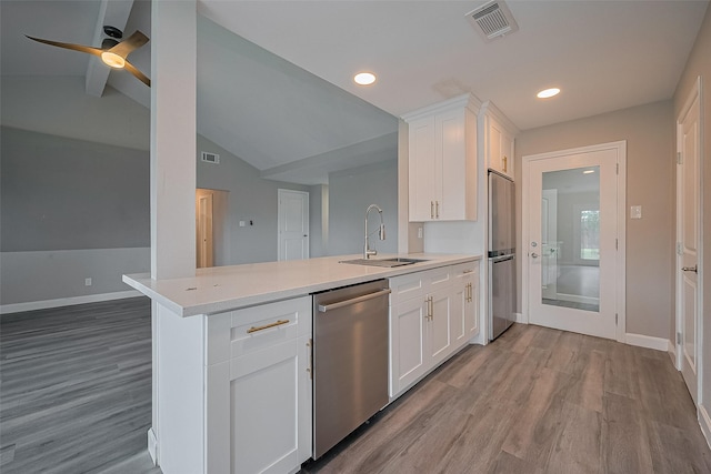 11502 Leader St, Houston, TX 77072 - kitchen featuring stainless steel appliances, a peninsula, light wood-style flooring, vaulted ceiling, and light countertops