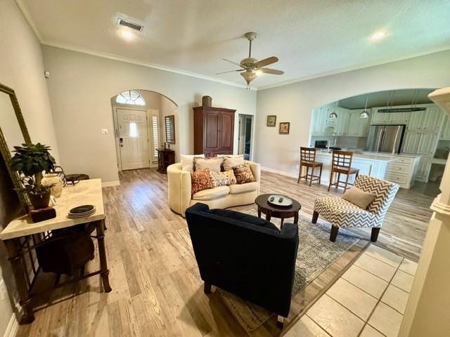 108 Audubon Woods Dr, Richwood, TX 77531 - living area featuring arched walkways, ceiling fan, light wood-style flooring, and ornamental molding