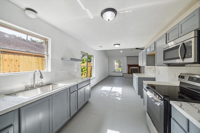 604 Briarclift Ln, Baytown, TX 77521 - kitchen featuring appliances with stainless steel finishes, backsplash, and gray cabinetry