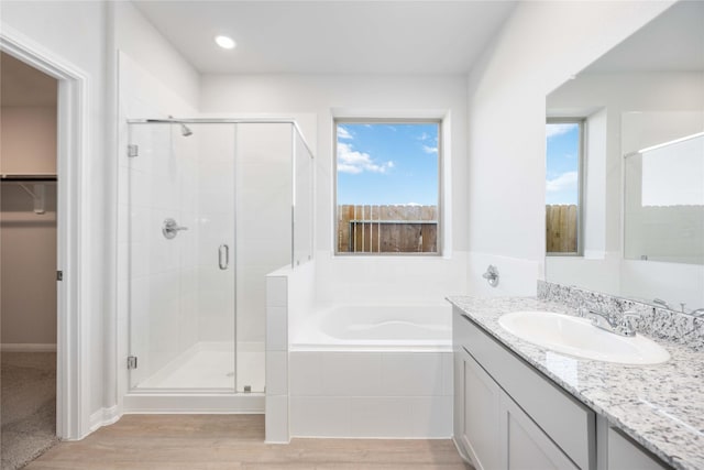 16866 Needlepoint Dr, Conroe, TX 77302 - full bath featuring a shower stall, a spacious closet, a bath, vanity, and wood finished floors