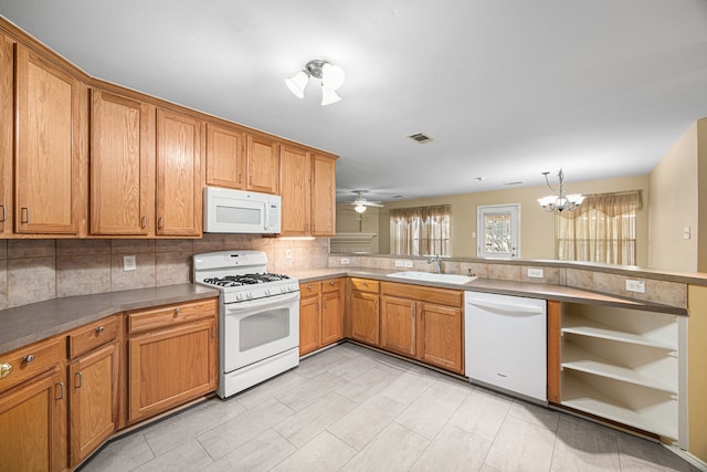 14319 Heron Marsh Dr, Cypress, TX 77429 - kitchen with white appliances, tasteful backsplash, a chandelier, and brown cabinetry
