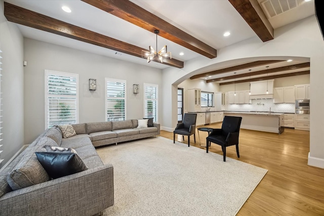 1116 W Drew St, Houston, TX 77006 - living area featuring arched walkways, recessed lighting, light wood finished floors, beamed ceiling, and a chandelier