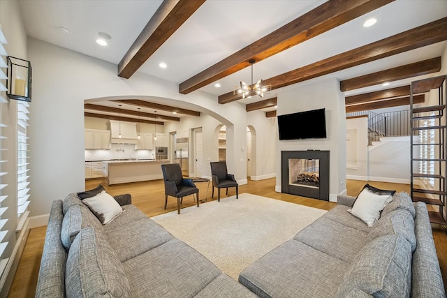 1116 W Drew St, Houston, TX 77006 - living area with arched walkways, light wood-type flooring, recessed lighting, a fireplace, and a chandelier