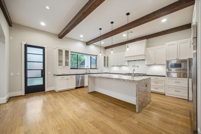 1116 W Drew St, Houston, TX 77006 - kitchen with premium range hood, a warming drawer, appliances with stainless steel finishes, backsplash, and beamed ceiling