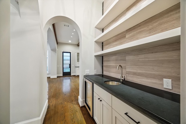 1116 W Drew St, Houston, TX 77006 - indoor wet bar featuring dark wood-style floors, wine cooler, recessed lighting, and arched walkways