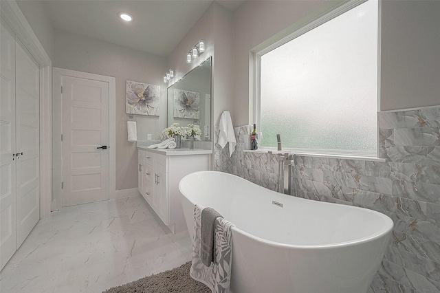 7108 Saint Augustine St, Houston, TX 77021 - bathroom featuring marble finish flooring, vanity, a freestanding bath, tile walls, and recessed lighting