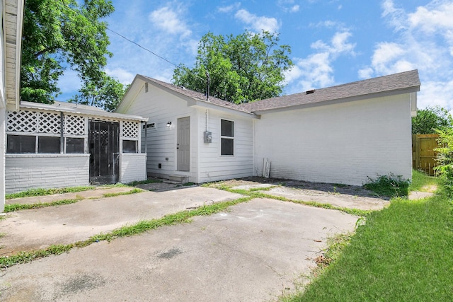 8221 Hezekiah Ln, Houston, TX 77088 - rear view of property featuring a patio, brick siding, and a sunroom