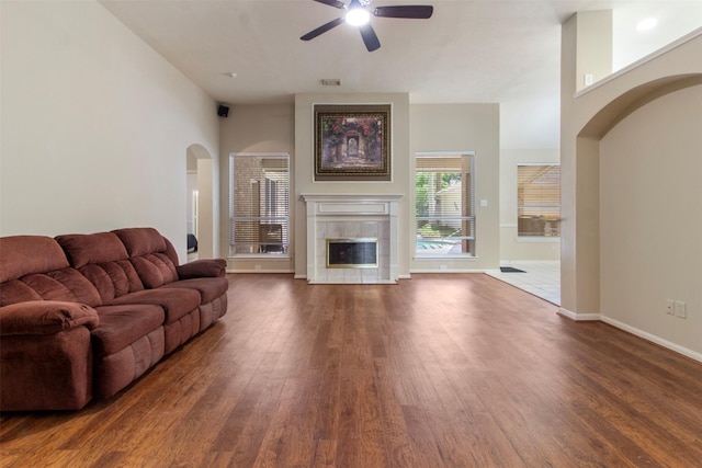 14510 Kings Head Dr, Houston, TX 77044 - living area with wood finished floors, ceiling fan, a tiled fireplace, and arched walkways