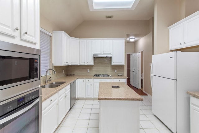 14510 Kings Head Dr, Houston, TX 77044 - kitchen with appliances with stainless steel finishes, a center island, decorative backsplash, under cabinet range hood, and light tile patterned flooring
