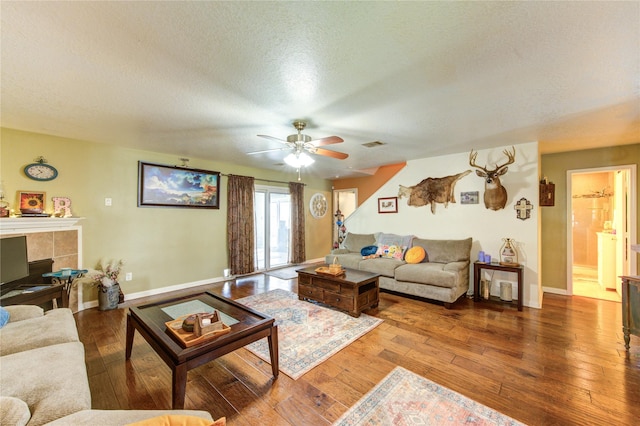 11734 Filaree Trl, Houston, TX 77044 - living area featuring a textured ceiling, wood-type flooring, ceiling fan, and a tiled fireplace