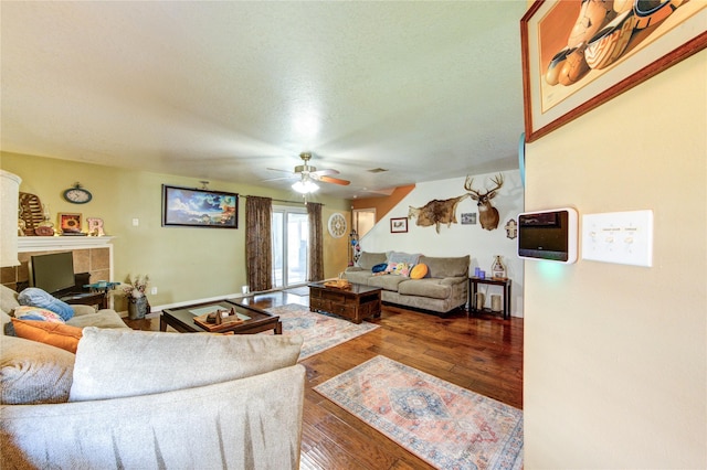 11734 Filaree Trl, Houston, TX 77044 - living room featuring a fireplace, ceiling fan, wood-type flooring, and a textured ceiling