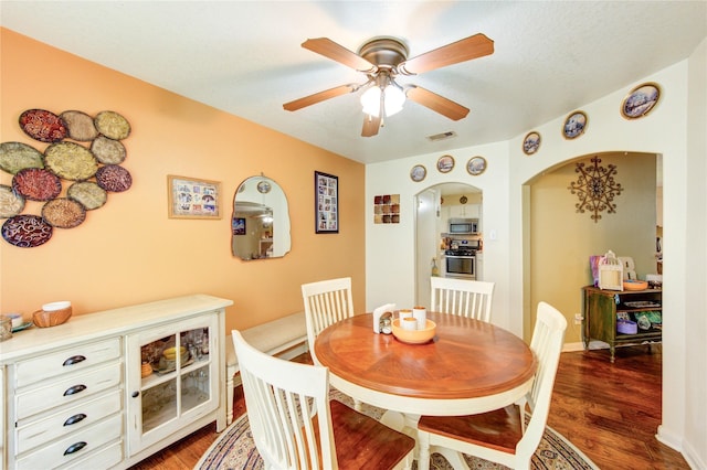 11734 Filaree Trl, Houston, TX 77044 - dining space with arched walkways, ceiling fan, and dark wood finished floors