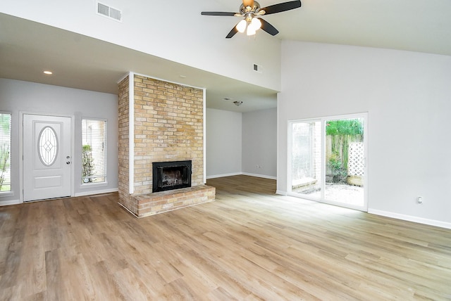 1010 Rock Canyon Dr, Katy, TX 77450 - unfurnished living room featuring a ceiling fan, light wood-style flooring, a brick fireplace, high vaulted ceiling, and recessed lighting