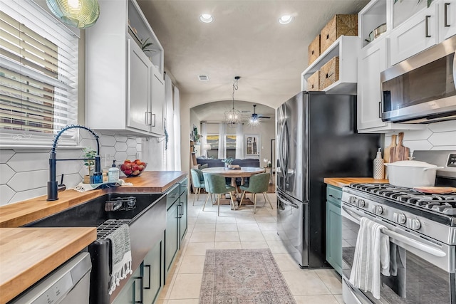 27502 Macy Hills Ct, Spring, TX 77386 - kitchen with wood counters, appliances with stainless steel finishes, tasteful backsplash, recessed lighting, and pendant lighting
