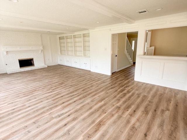 16627 Aldenham Pl, Spring, TX 77379 - unfurnished living room with wood finished floors, a decorative wall, beamed ceiling, ornamental molding, and stairs