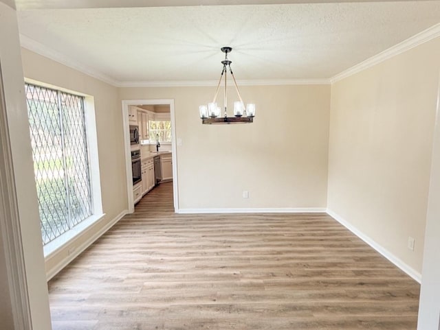 16627 Aldenham Pl, Spring, TX 77379 - unfurnished dining area featuring a chandelier, ornamental molding, and light wood-style flooring