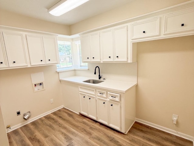 16627 Aldenham Pl, Spring, TX 77379 - laundry room featuring washer hookup, light wood finished floors, and cabinet space