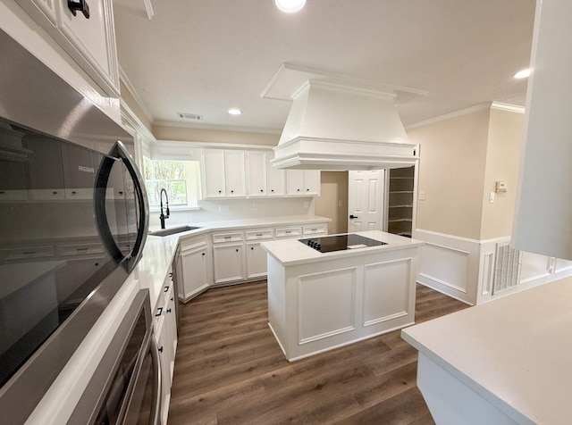 16627 Aldenham Pl, Spring, TX 77379 - kitchen with black electric cooktop, refrigerator, custom range hood, crown molding, and a center island