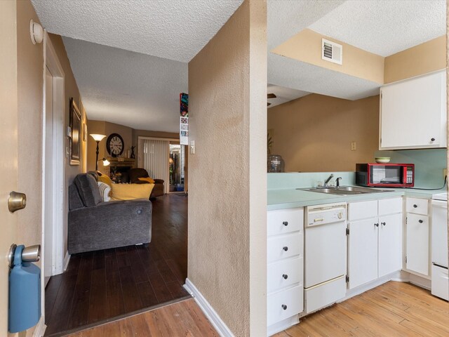 1505 Ward Rd Unit 215, Baytown, TX 77520 - kitchen featuring white appliances, a textured ceiling, a textured wall, light wood-style flooring, and open floor plan
