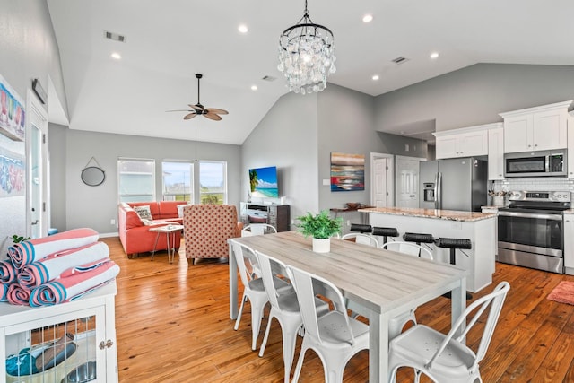 18607 Warrior Rd, Galveston, TX 77554 - dining space featuring ceiling fan, light wood-style floors, high vaulted ceiling, a chandelier, and recessed lighting