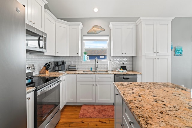 18607 Warrior Rd, Galveston, TX 77554 - kitchen featuring stainless steel appliances, wood finished floors, recessed lighting, backsplash, and white cabinetry