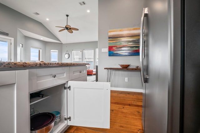 18607 Warrior Rd, Galveston, TX 77554 - kitchen featuring freestanding refrigerator, lofted ceiling, a ceiling fan, wood finished floors, and white cabinetry