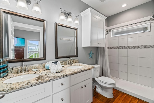 18607 Warrior Rd, Galveston, TX 77554 - full bath with double vanity, a tile shower, and wood finished floors