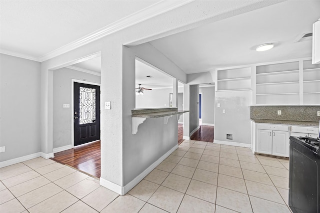 4535 Clermont Ave, Groves, TX 77619 - kitchen with open shelves, light tile patterned flooring, ornamental molding, white cabinets, and ceiling fan