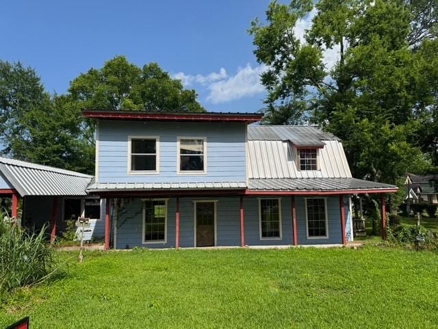 771 Governor Wood Dr, Point Blank, TX 77364 - back of property with a lawn, a metal roof, and covered porch