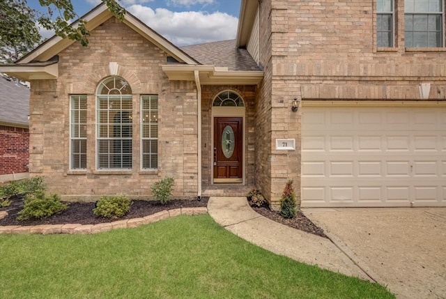 71 N Merryweather Cir, Conroe, TX 77384 - property entrance with brick siding, roof with shingles, a lawn, and concrete driveway