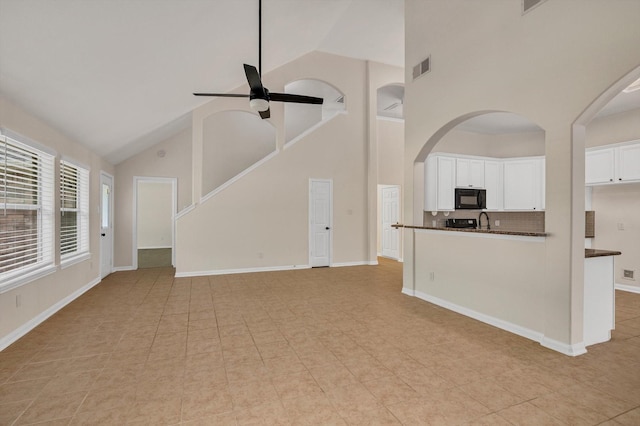 71 N Merryweather Cir, Conroe, TX 77384 - unfurnished living room featuring high vaulted ceiling, ceiling fan, arched walkways, and light tile patterned floors