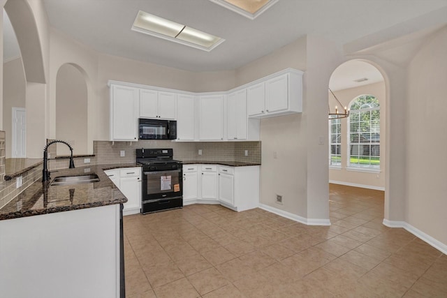 71 N Merryweather Cir, Conroe, TX 77384 - kitchen with black appliances, dark stone counters, decorative backsplash, light tile patterned flooring, and white cabinetry