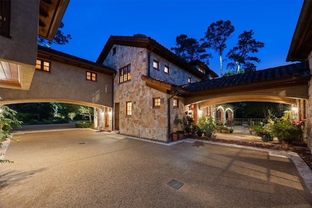 603 W Friar Tuck Ln, Houston, TX 77024 - patio at night featuring concrete driveway and a patio