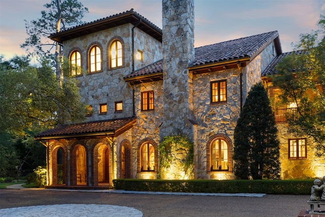 603 W Friar Tuck Ln, Houston, TX 77024 - mediterranean / spanish-style home with stone siding, a chimney, and a tile roof