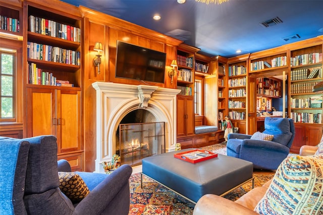 603 W Friar Tuck Ln, Houston, TX 77024 - living area featuring bookshelves, a warm lit fireplace, built in shelves, and recessed lighting
