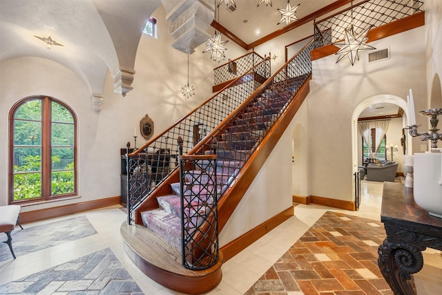 603 W Friar Tuck Ln, Houston, TX 77024 - stairs with arched walkways, a towering ceiling, and crown molding