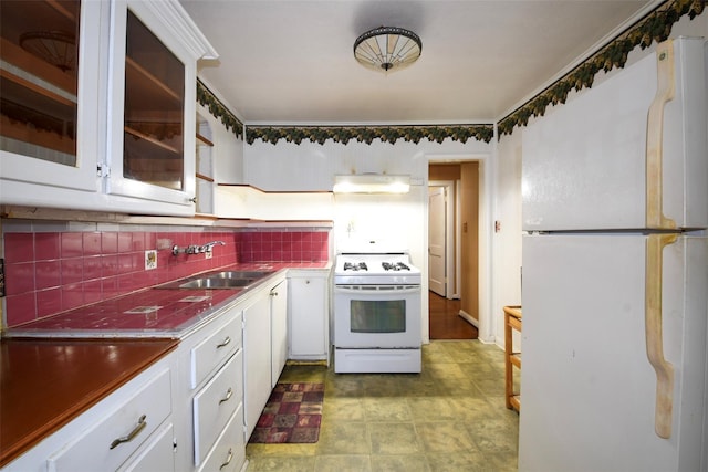 3614 Billingsley St, Houston, TX 77009 - kitchen with white appliances, under cabinet range hood, white cabinetry, tasteful backsplash, and glass insert cabinets