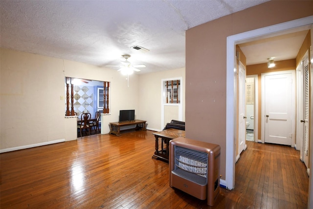 3614 Billingsley St, Houston, TX 77009 - living room with heating unit, wood-type flooring, a ceiling fan, and a textured ceiling