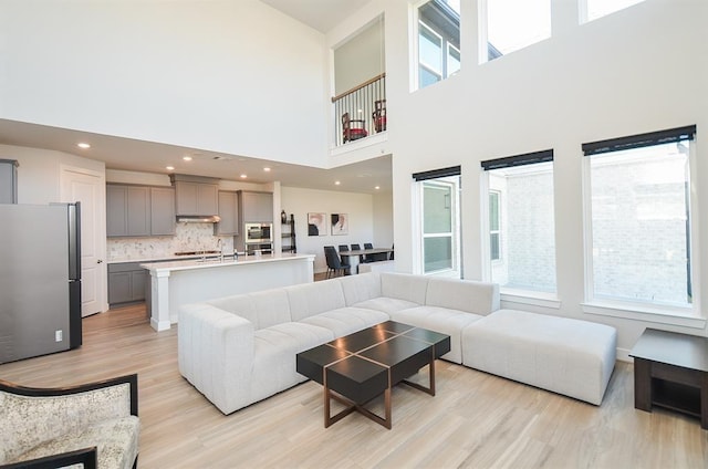 9522 Rialto Creek Dr, Cypress, TX 77433 - living room featuring light wood-style floors, a towering ceiling, and recessed lighting