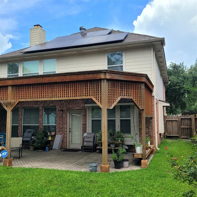 110 Greenridge Cir, League City, TX 77573 - back of property featuring roof mounted solar panels, a patio area, and brick siding