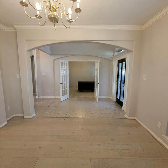 110 Greenridge Cir, League City, TX 77573 - corridor featuring arched walkways, french doors, a chandelier, light wood-style floors, and crown molding