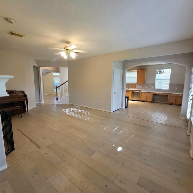 110 Greenridge Cir, League City, TX 77573 - unfurnished living room with arched walkways, light wood-style floors, ceiling fan, and a chandelier