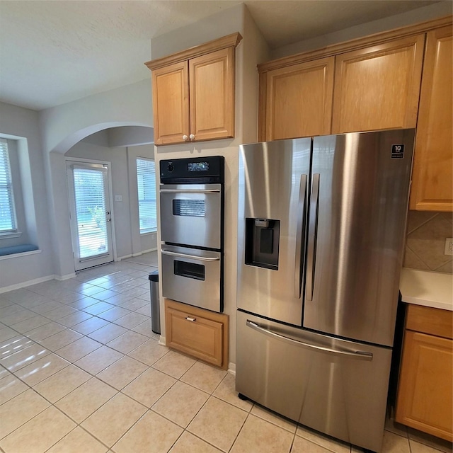 110 Greenridge Cir, League City, TX 77573 - kitchen with stainless steel appliances, arched walkways, light tile patterned floors, and light countertops
