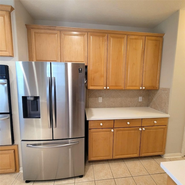 110 Greenridge Cir, League City, TX 77573 - kitchen featuring stainless steel fridge, light countertops, light tile patterned flooring, and decorative backsplash