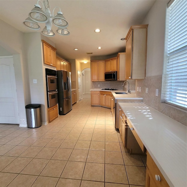 110 Greenridge Cir, League City, TX 77573 - kitchen featuring stainless steel appliances, arched walkways, light tile patterned flooring, light countertops, and backsplash