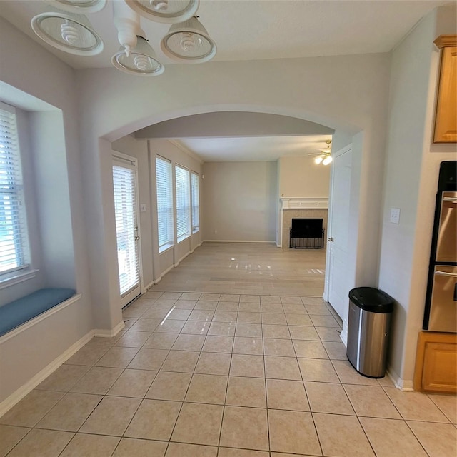 110 Greenridge Cir, League City, TX 77573 - unfurnished dining area featuring arched walkways, ceiling fan, light tile patterned flooring, and a fireplace