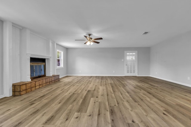 10650 Forest Creek Dr, Conroe, TX 77318 - unfurnished living room with ceiling fan, wood finished floors, healthy amount of natural light, and a glass covered fireplace