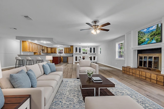 10650 Forest Creek Dr, Conroe, TX 77318 - living area featuring a glass covered fireplace, light wood-type flooring, and a ceiling fan
