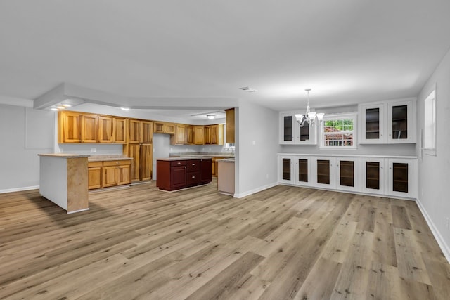 10650 Forest Creek Dr, Conroe, TX 77318 - kitchen featuring a chandelier, light wood-style floors, light countertops, brown cabinets, and decorative light fixtures